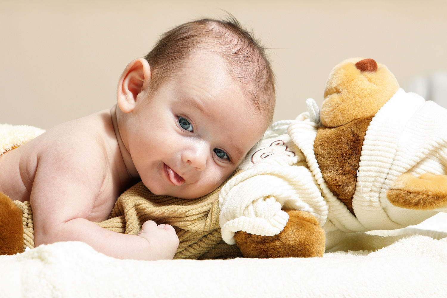 En baby der ligger med hovedet ovenpå en blød bamse