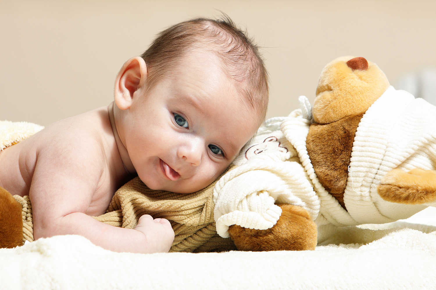 En baby der ligger med hovedet ovenpå en blød bamse