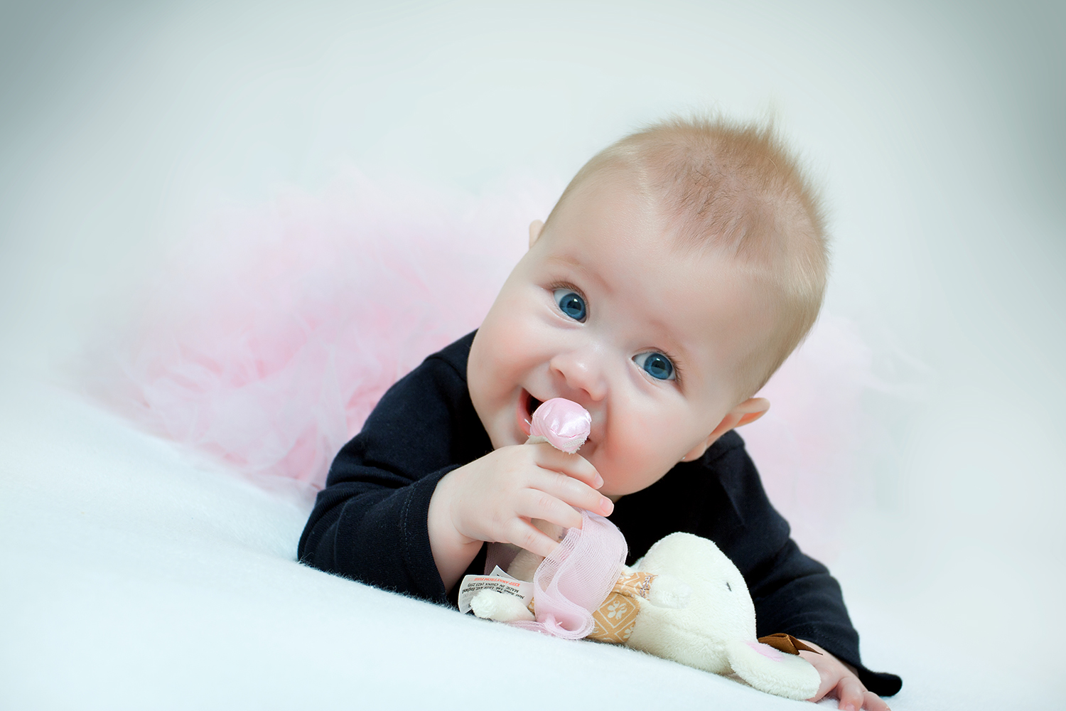 Glad baby der ligger og bider i hendes bamse