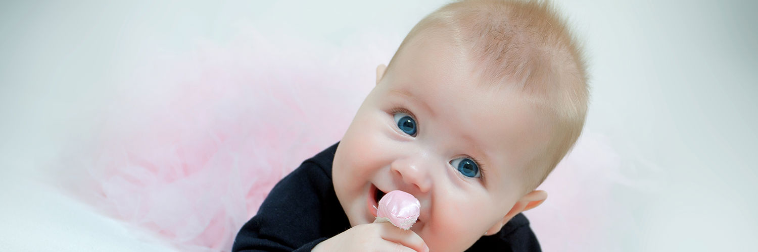 Glad baby der ligger og bider i hendes bamse