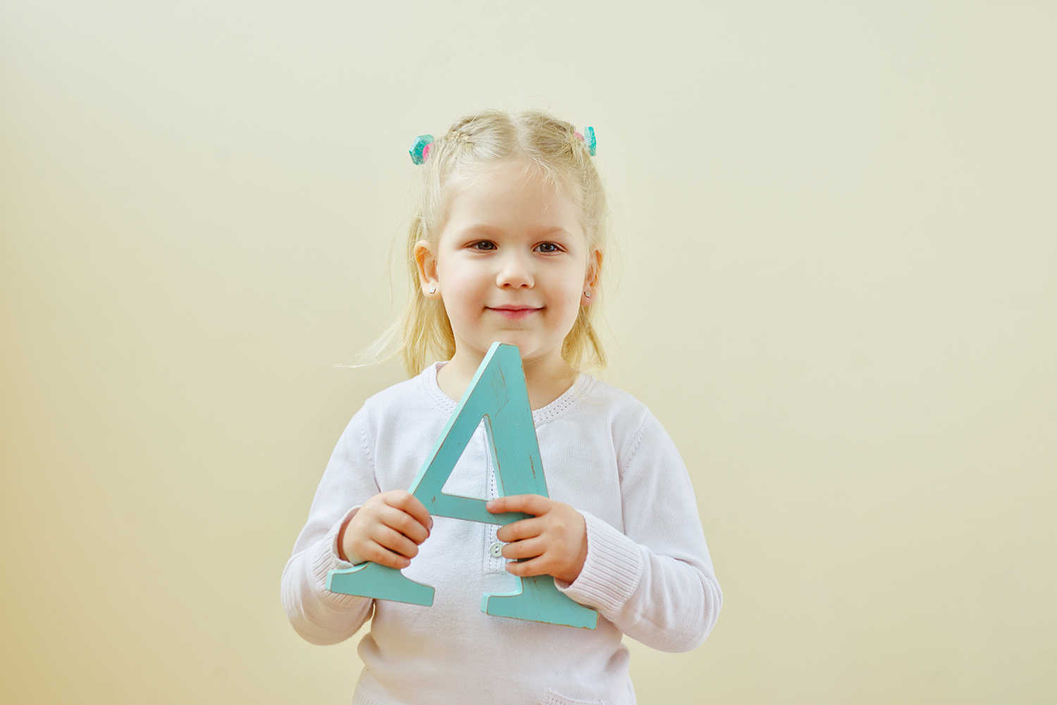 Pige der står med et bogstavet a i hendes hænder