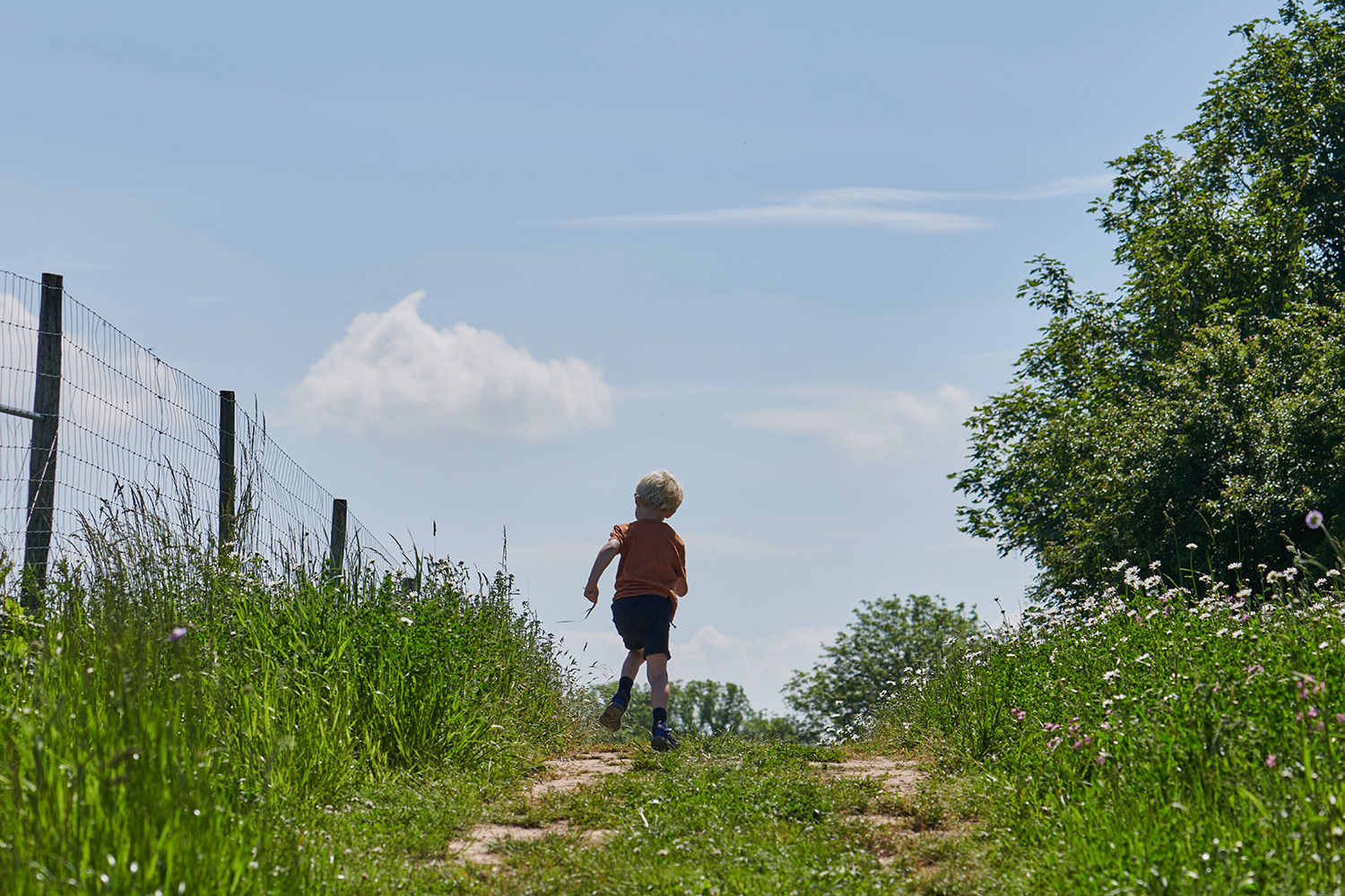 Dreng der løber på en marksti
